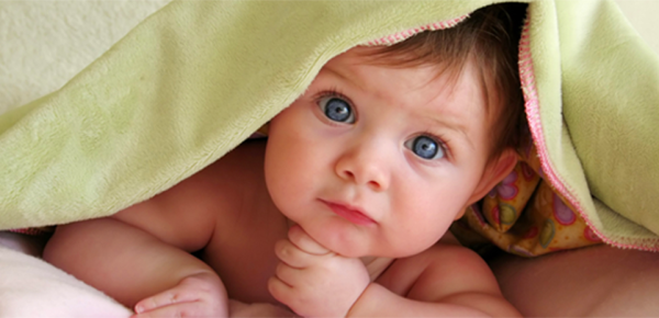 Cute baby under a green blanket
