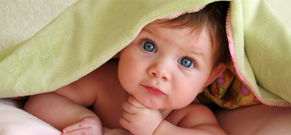Cute baby under a green blanket